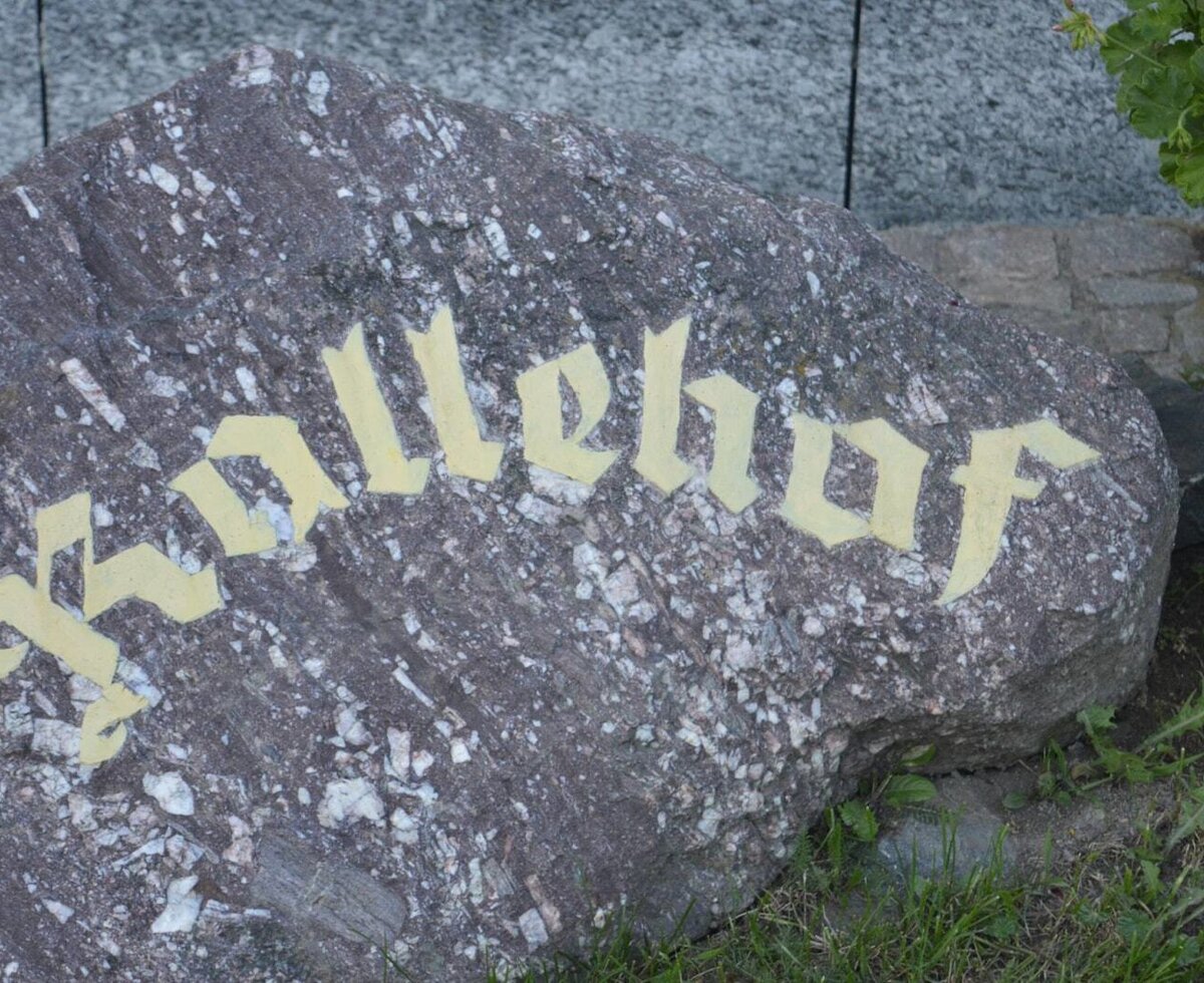 Der Schriftzug "Krallehof" auf einem Naturstein, der den Bauernhof identifiziert.