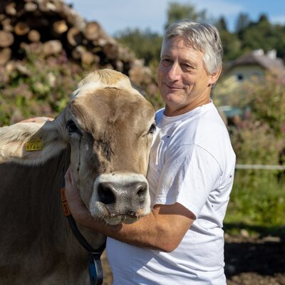 Der Bauer des Bauernhofs mit einer seiner Kühe.