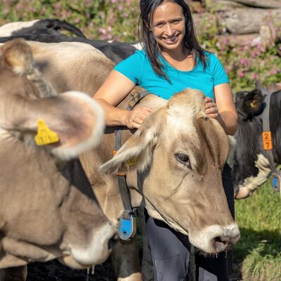 Eine Frau streichelt eine Kuh auf dem Bauernhof.