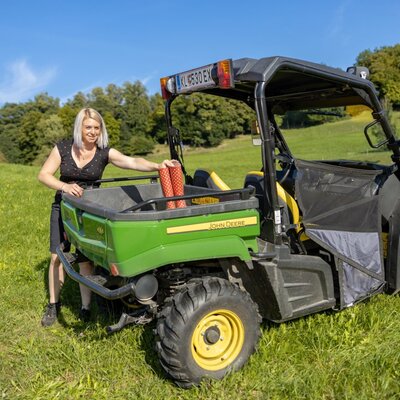 Ein John Deere Nutzfahrzeug auf dem Bauernhof, bereit für Aktivitäten in der Natur.