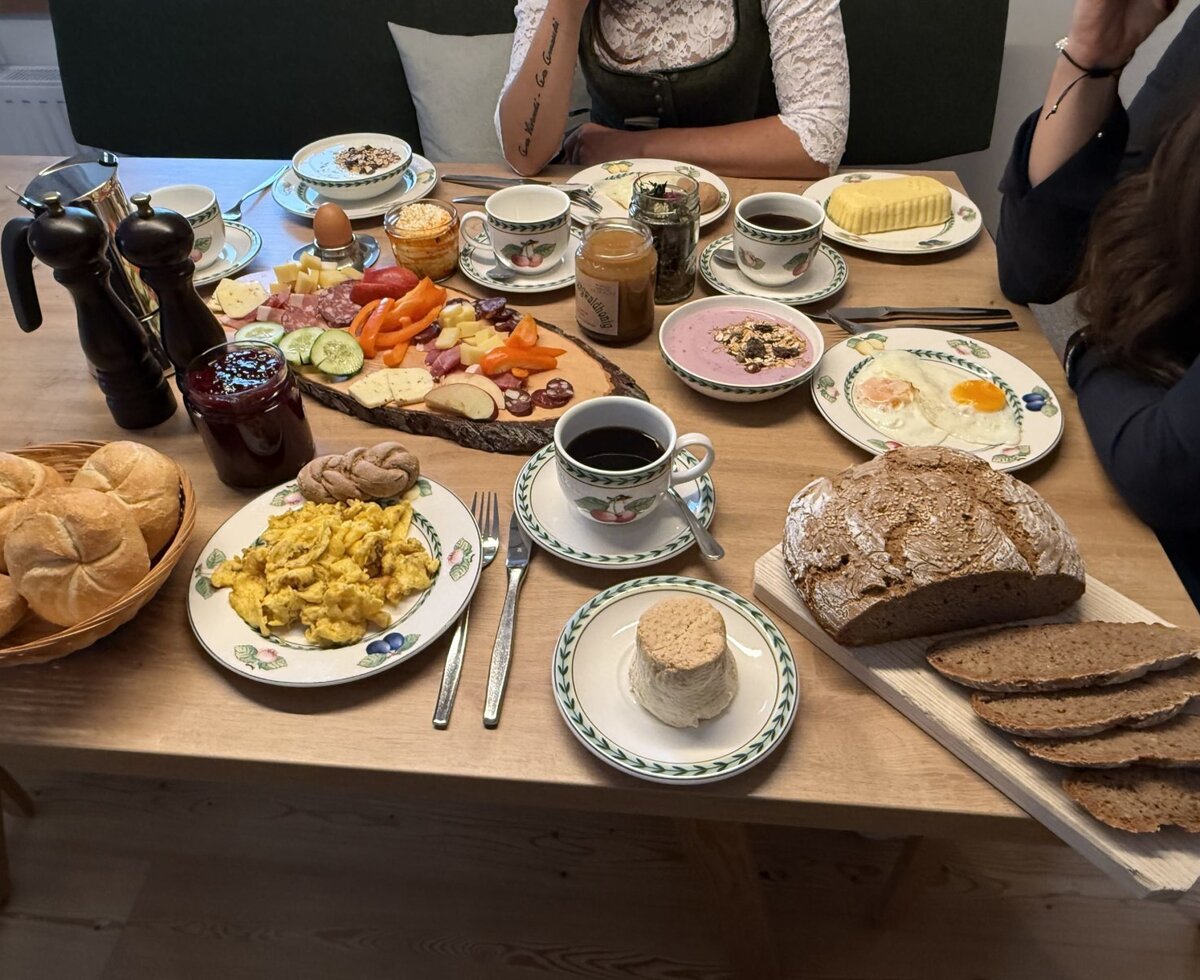 Frühstückstisch in der Ferienwohnung mit einer Auswahl an Eiern, Brot, Aufschnitt, Käse, Marmelade und Kaffee.
