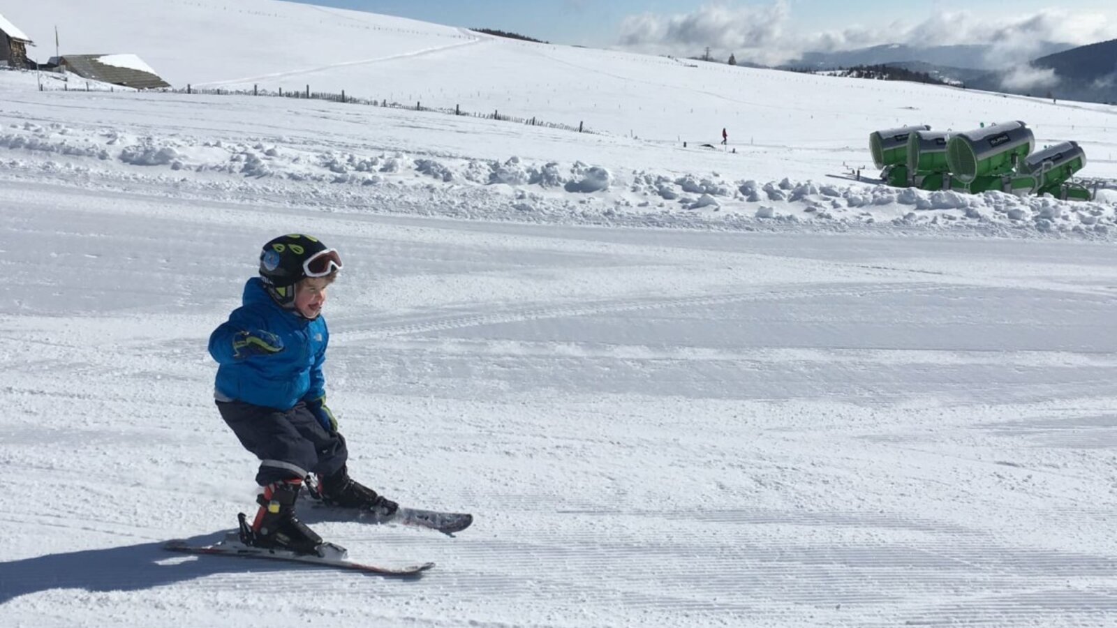 Skifahren für Kinder auf einer präparierten Piste in der winterlichen Umgebung des Bauernhofs.