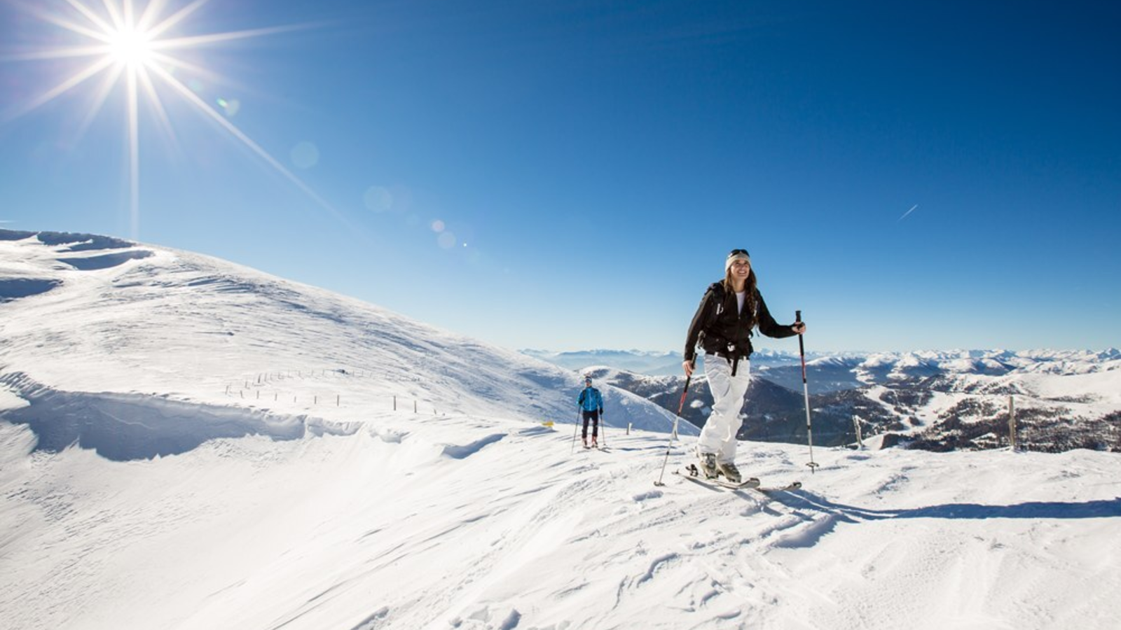 Skitouren auf einem verschneiten Berg unter blauem Himmel, eine Aktivität, die in der Nähe des Bauernhofs möglich ist.