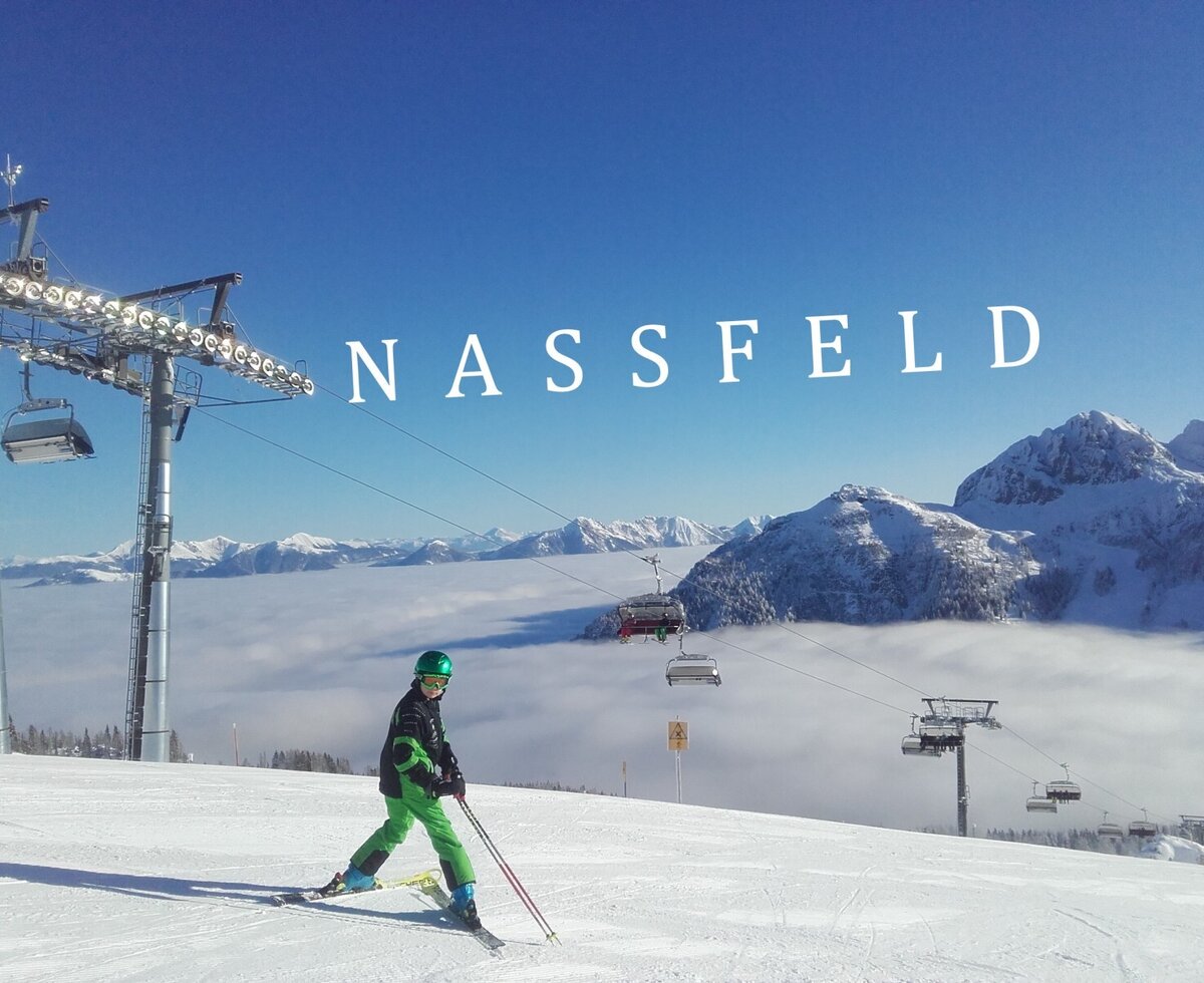 Wintersportmöglichkeiten in Nassfeld mit einem Skifahrer auf der Piste und einem Bergpanorama über den Wolken.