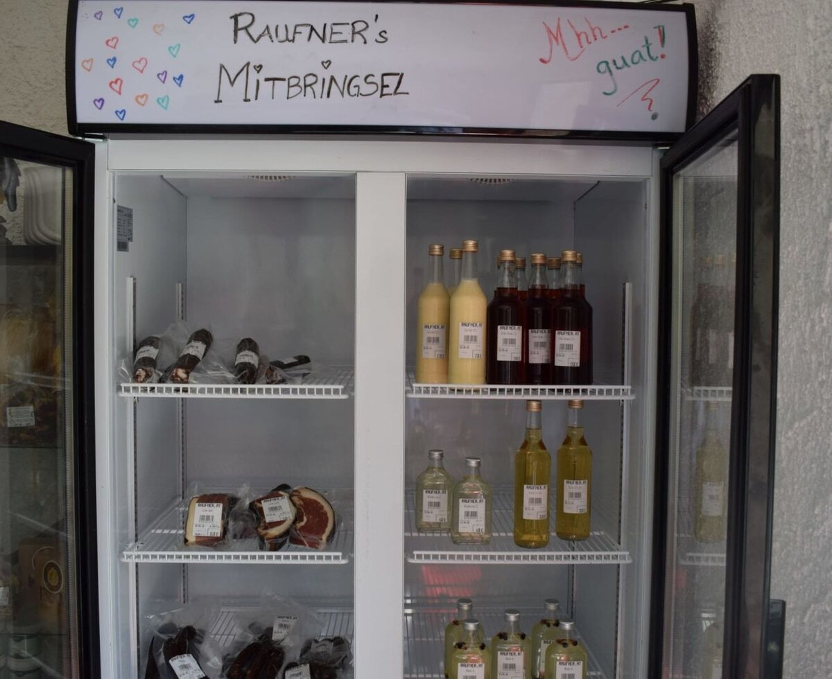 Ein gut sortierter Verkaufskühlschrank im Gasthof Raufner mit regionalen Spezialitäten und hausgemachten Mitbringseln.