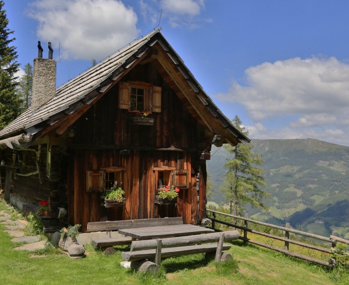 Die Hütte mit Außensitzbereich und Blick auf die Berge.