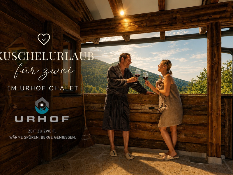Gäste genießen auf der Holzterrasse des Chalets den Bergblick bei einem Glas Wein.