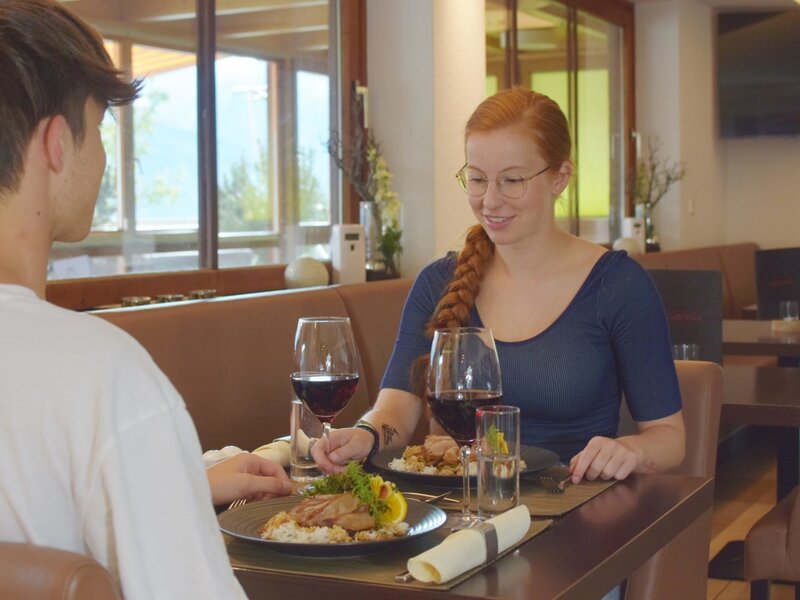 Gäste speisen im À-la-carte-Restaurant des Bauernhofs.