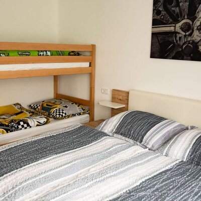 Schlafzimmer im Alpakahof mit Doppelbett und Etagenbett.