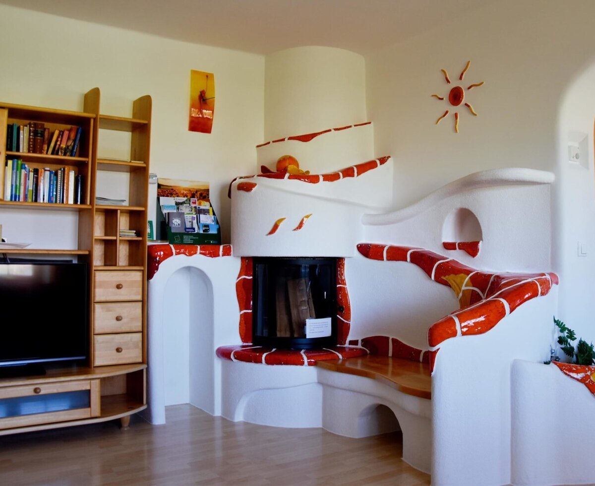 Der Wohnbereich mit Kachelofen und Fernseher.