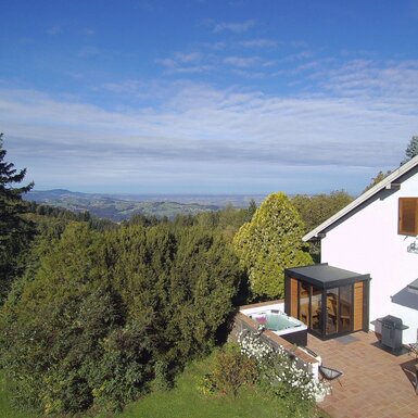 Außenansicht mit Terrasse, Essbereich im Freien, Whirlpool und Blick auf die umliegende Landschaft.