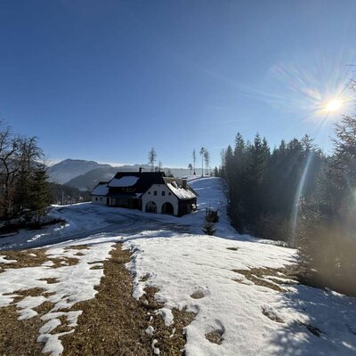 Verschneite Berglandschaft unter blauem Himmel mit Sonnenschein.
