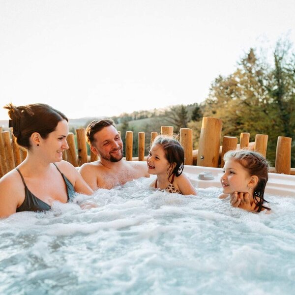 Familie im Whirlpool im Chalet.