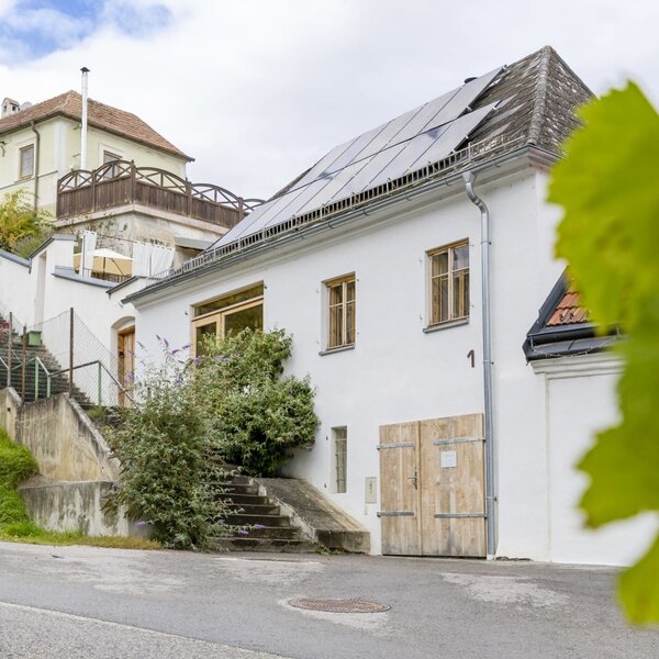 Die Fassade der Greisslerei mit Solarpaneelen auf dem Dach.