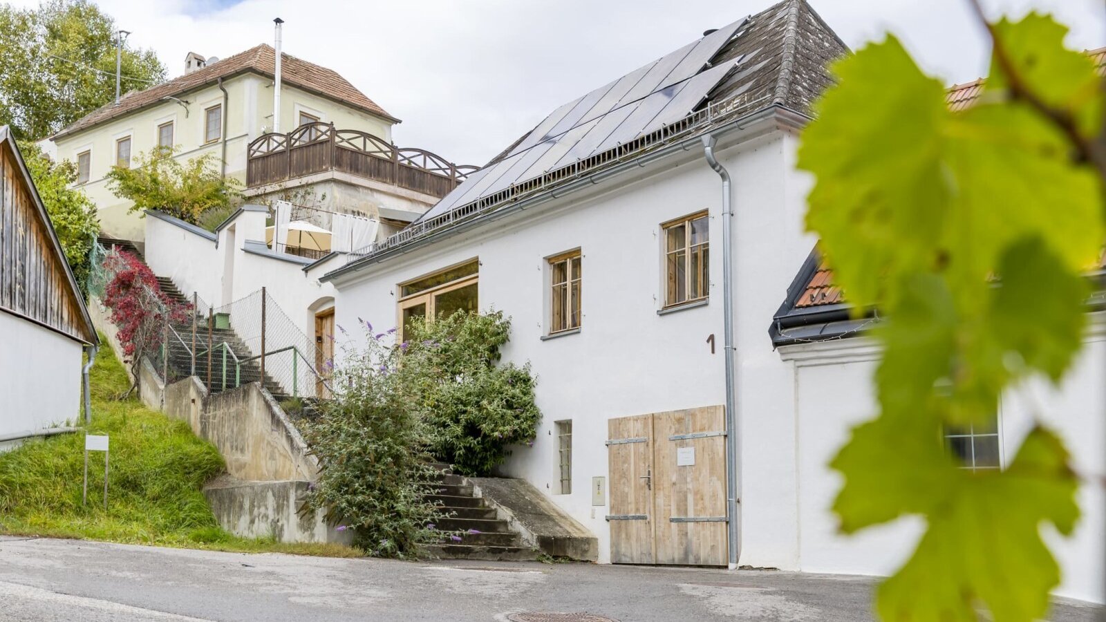 Die Fassade der Greisslerei mit Solarpaneelen auf dem Dach.