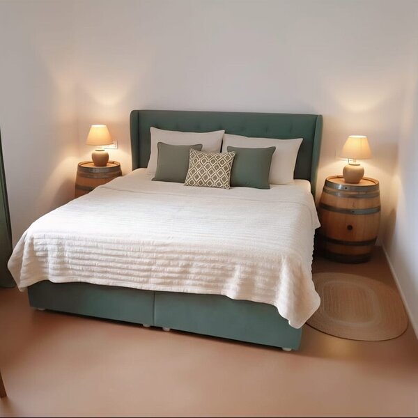 Ein gemütliches Schlafzimmer im Winzerhof mit einem einladenden Doppelbett und rustikalen Weinfässern als Nachttische.