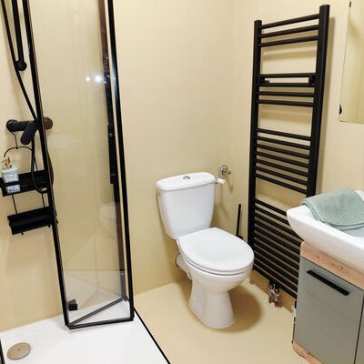 Ein modern gestaltetes Badezimmer des Winzerhofes mit einer eleganten Dusche, einem Handtuchwärmer und einem stilvollen Waschtisch.