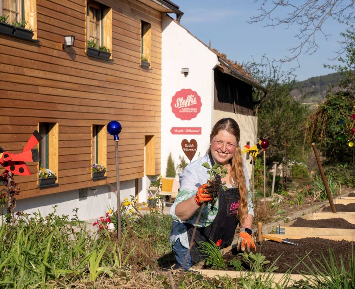 Frau Stefanie bepflanzt den Garten des Landhofs, der frische Naturprodukte anbietet.