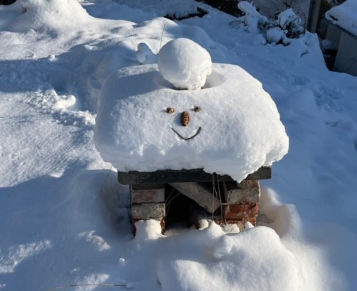 Ein lächelndes Schneegesicht am Kellerschlot