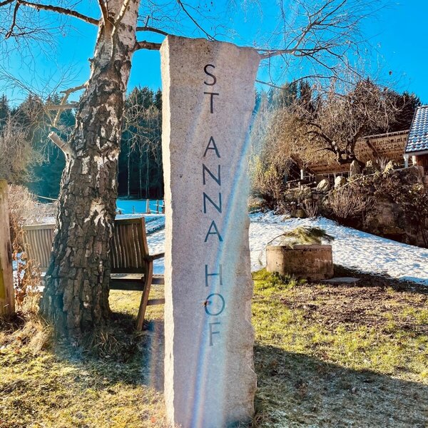 Steinerner Pfeiler mit der Aufschrift "ST ANNA HOF" kennzeichnet den Bauernhof.