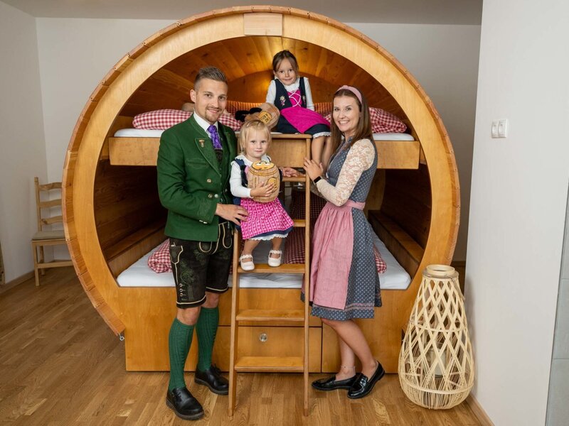 Weinfass-Suite im Winzerhof mit Etagenbett in einem großen Holzfass.