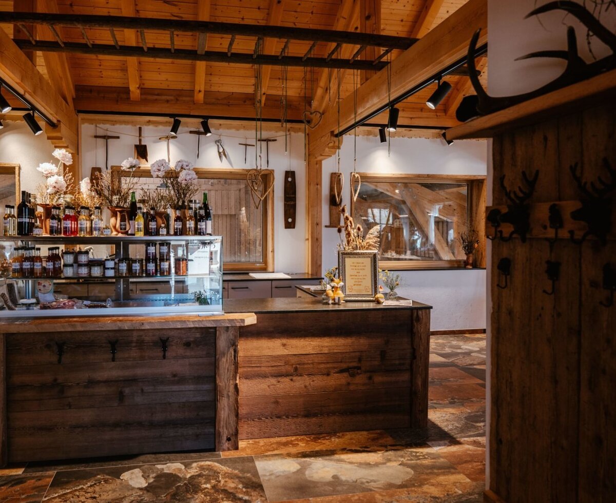 Hofladen des Bauernhofs mit einer Theke und einer Vitrine voller regionaler Produkte.