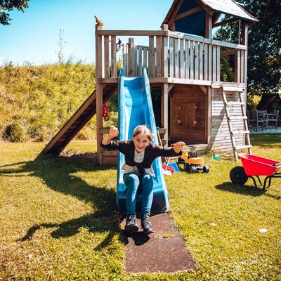 Der Bauernhof verfügt über einen Spielplatz mit Rutsche und Spielturm für Kinder.