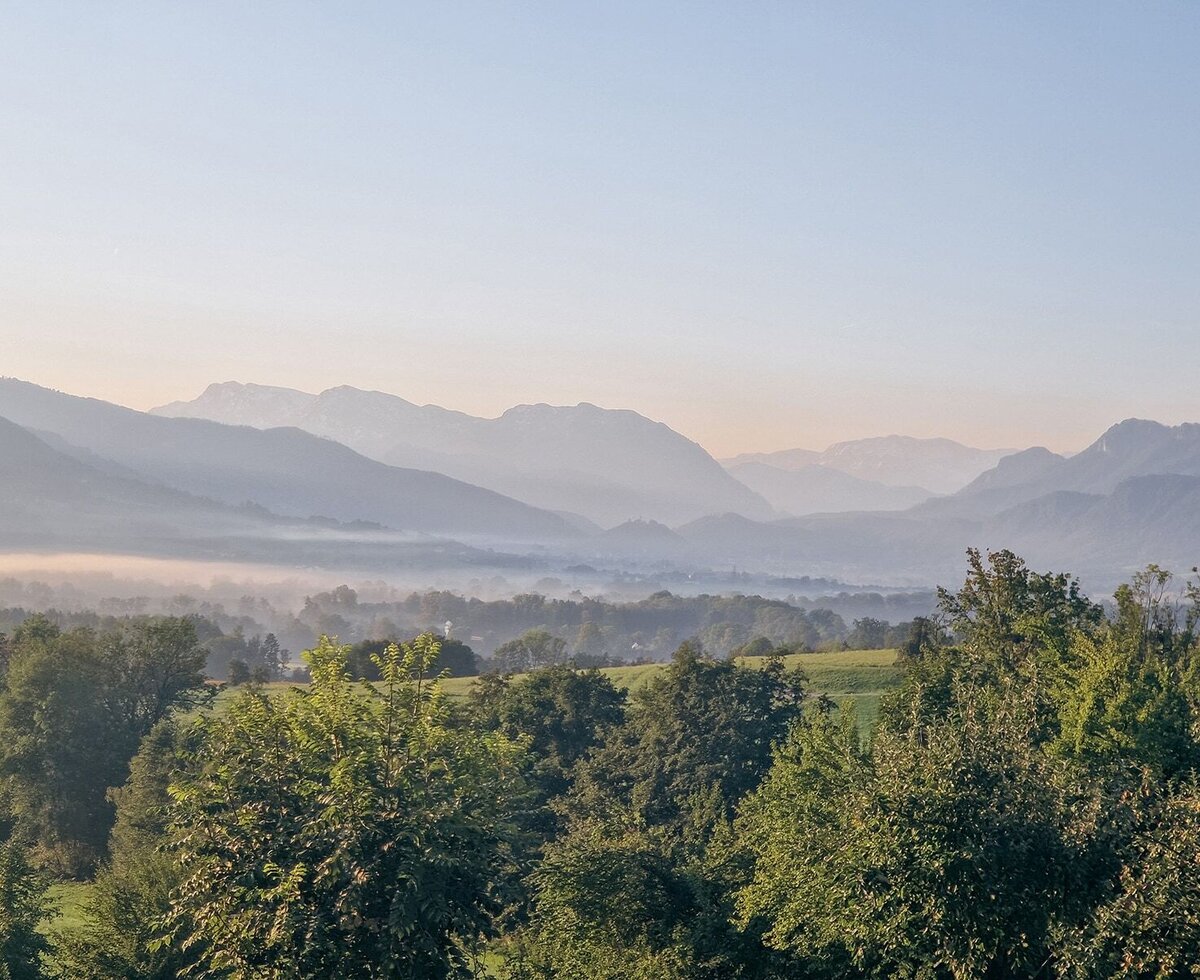 Malerischer Blick vom Ferienapartment auf das neblige Alpenvorland am Morgen.