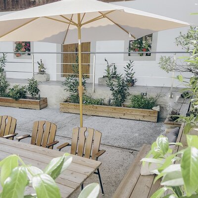 Durch den Haupteingang und das Vorhaus gelangen Sie in unseren Innenhof – Ihre kleine Wohlfühloase mit Sitzgelegenheiten, Sonnenschirmen sowie Kräutern und Blumen.