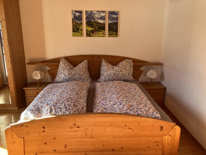 Sonniges Schlafzimmer mit Doppelbett und Balkon.