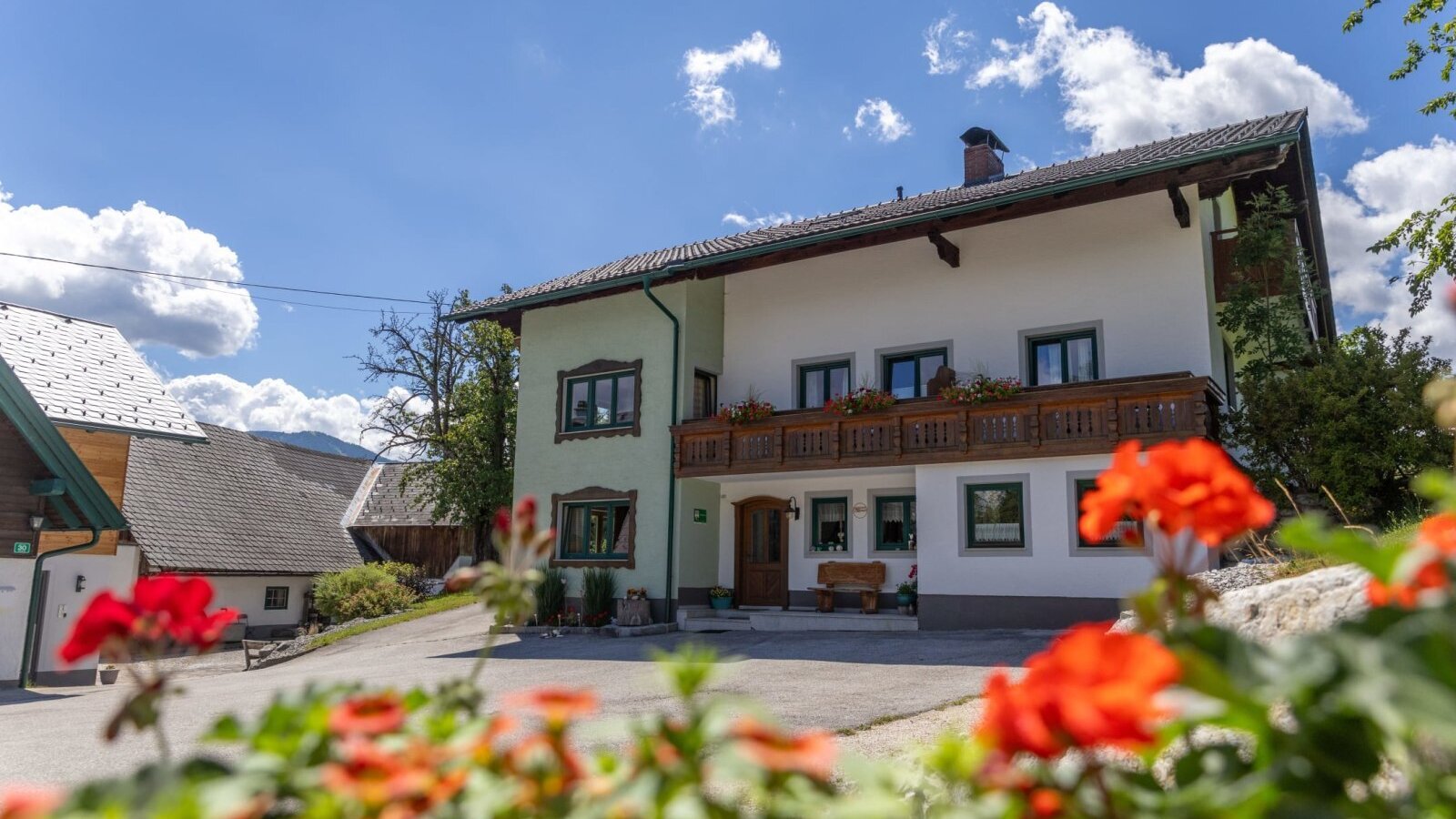 Unser Ferienhof Mittermair mit traditionellem Holzbalkon und blühendem Blumenschmuck