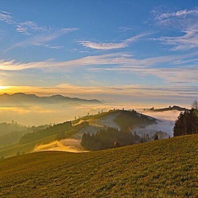 Sonnenuntergang über der Berglandschaft mit Nebel in den Tälern