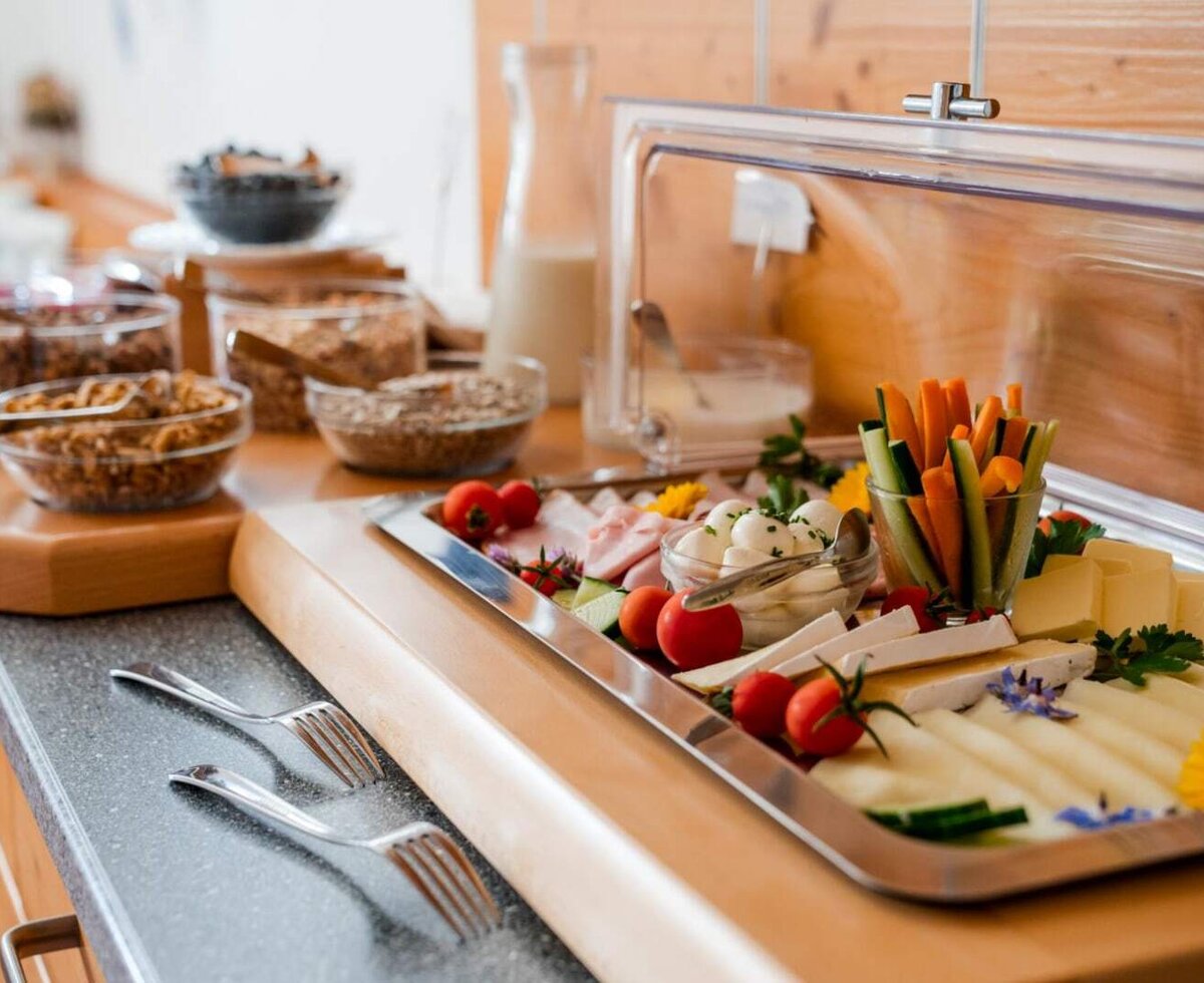 Das Frühstücksbuffet auf dem Bauernhof bietet Käse, Wurst, frisches Gemüse und verschiedene Müslisorten.
