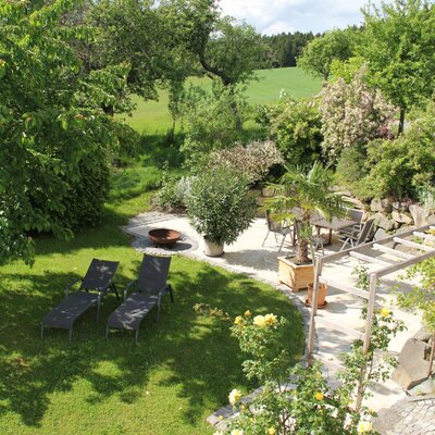 Der Garten des Bauernhofs bietet eine Rasenfläche, Sonnenliegen, eine gepflasterte Terrasse mit Tisch und Stühlen sowie eine Feuerstelle.