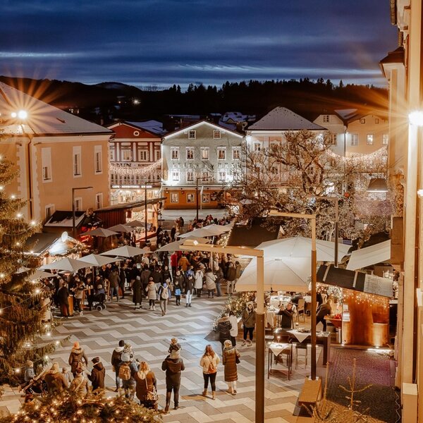Ein stimmungsvoller Weihnachtsmarkt auf dem nahegelegenen Dorfplatz mit festlicher Beleuchtung und einem großen, geschmückten Tannenbaum Mondsee.