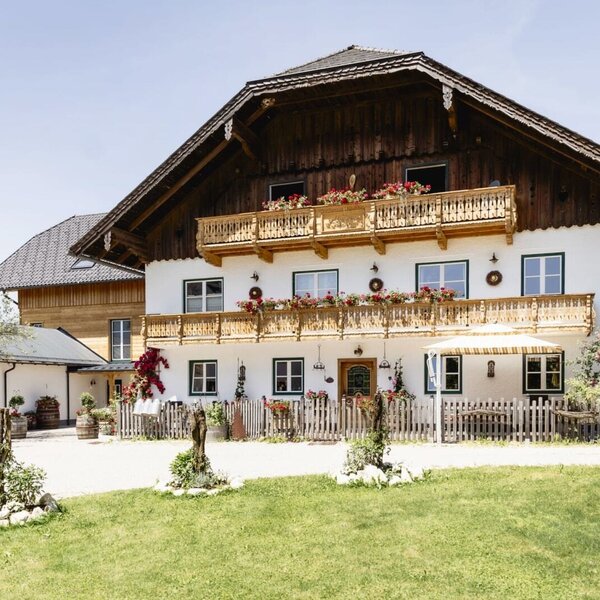 Außenansicht des Appartementsgebäudes mit traditioneller Architektur, Holzbalkonen und Blumenkästen.