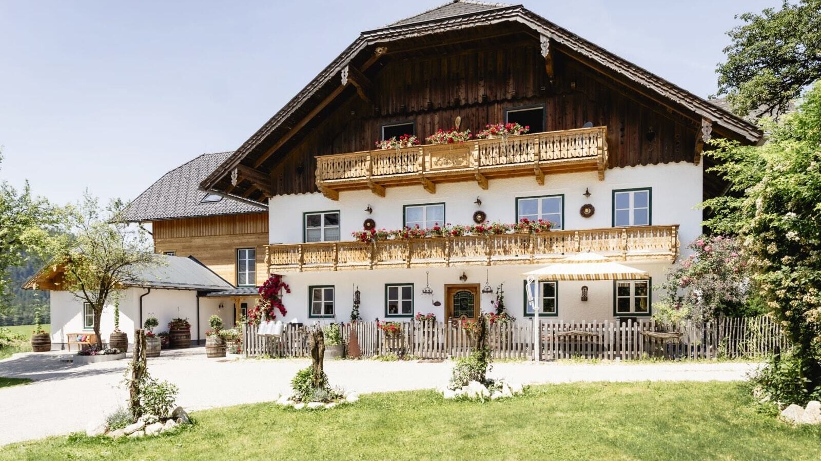 Außenansicht des Appartementsgebäudes mit traditioneller Architektur, Holzbalkonen und Blumenkästen.