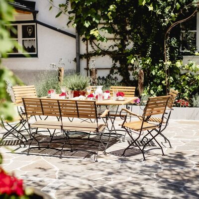 Die Terrasse der Appartements mit einem gedeckten Holztisch und Sitzgelegenheiten für Mahlzeiten oder Entspannung im Freien.