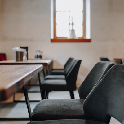 Der Speisebereich des Hofes mit Holztischen, gepolsterten Stühlen und einer Sitzbank.