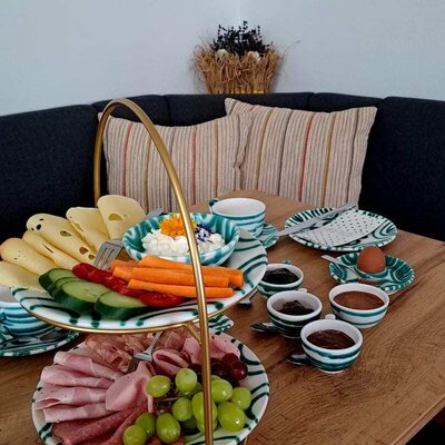Ein reichhaltiges und liebevoll angerichtetes Frühstück auf der gemütlichen Sitzecke.