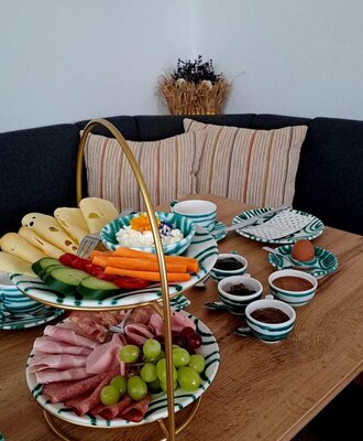 Ein reichhaltiges und liebevoll angerichtetes Frühstück auf der gemütlichen Sitzecke.