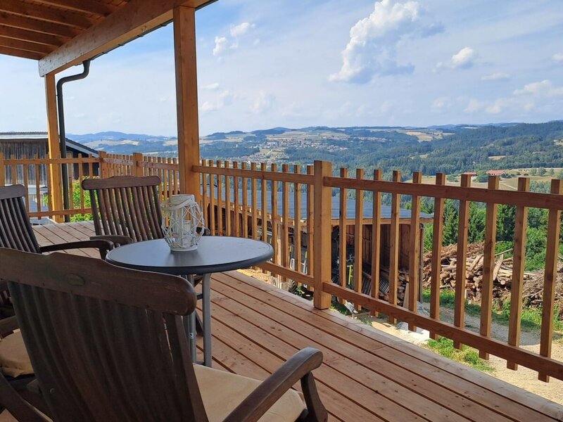 Die einladende Holzterrasse mit gemütlichen Sitzmöbeln und einem weitreichenden Panoramablick über das Mühlviertel.