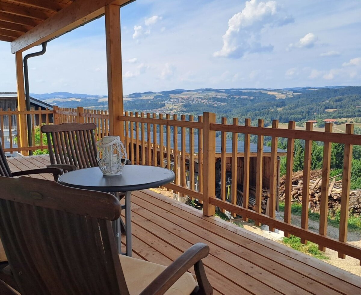 Die einladende Holzterrasse mit gemütlichen Sitzmöbeln und einem weitreichenden Panoramablick über das Mühlviertel.