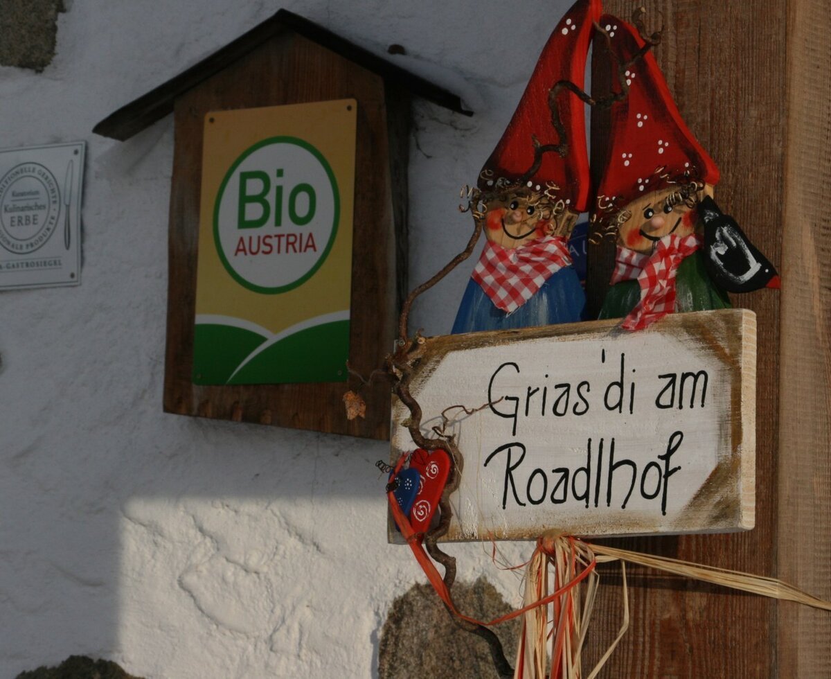Willkommensschild am Bauernhof Roadlhof mit Bio Austria und Traditionelles Kulinarisches Erbe Auszeichnungen.