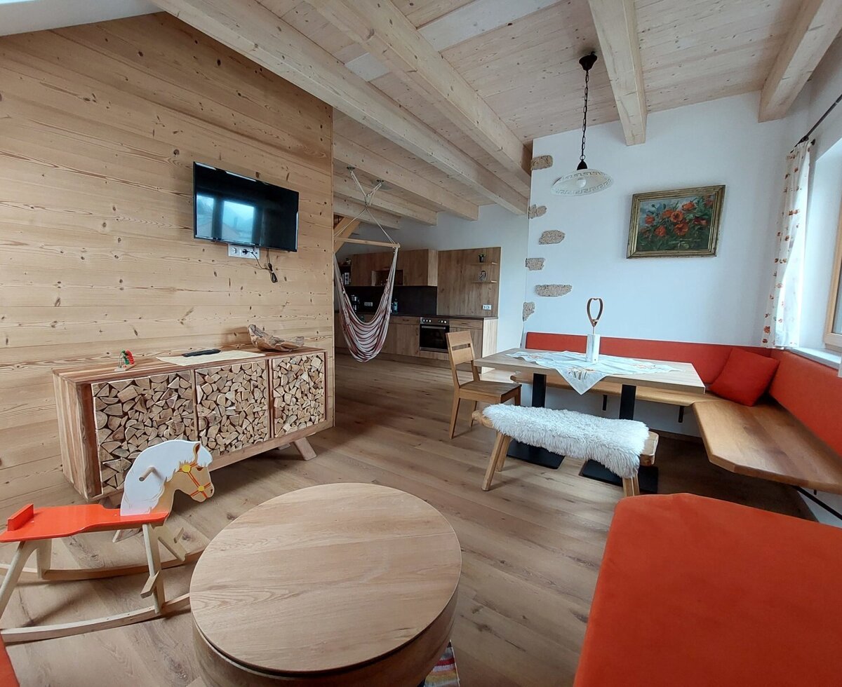 Der offene Wohn- und Essbereich des Bauernhofs ist ausgestattet mit einem Fernseher, einer Hängematte, einem Schaukelpferd und einer integrierten Küche.