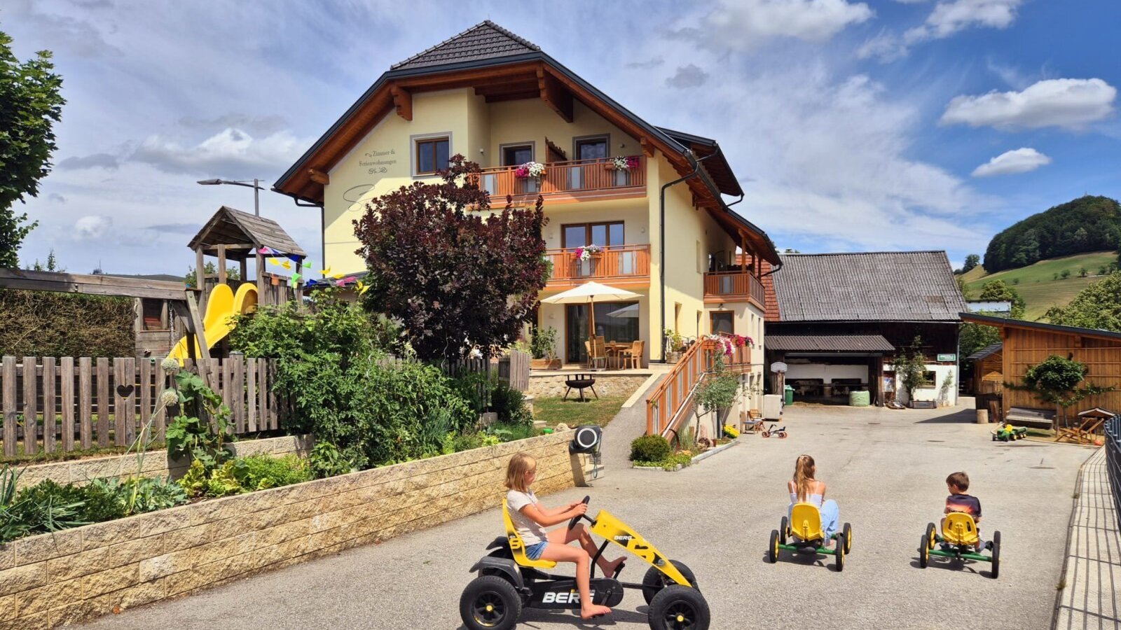 Der einladende Bauernhof mit einem großzügigen Spielbereich im Hof und einem Kinderspielplatz.