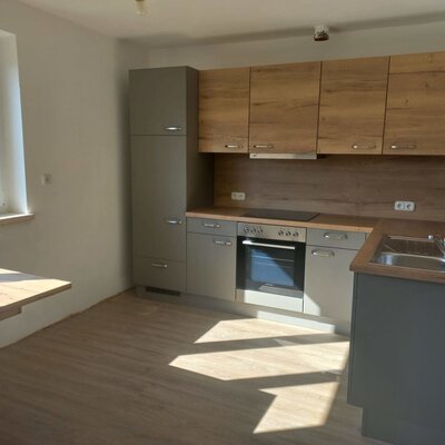 Küche im Bed and Breakfast mit Backofen, Kochfeld, Spüle und einem kleinen Esstisch am Fenster.