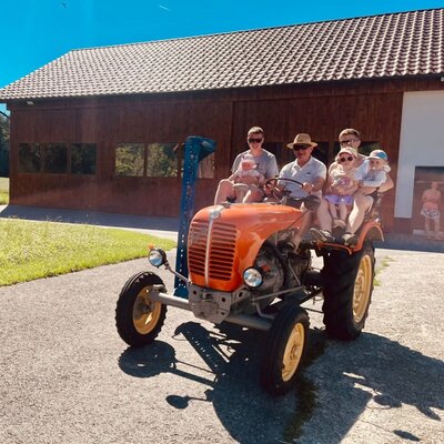 Ein charmanter Oldtimer-Traktor auf dem Bauernhof, der zu gemütlichen Rundfahrten an sonnigen Tagen einlädt.