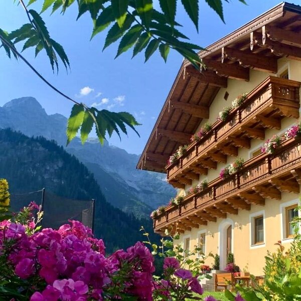 Außenansicht des Bauernhauses mit Sitzgelegenheiten vor und neben dem Haus.