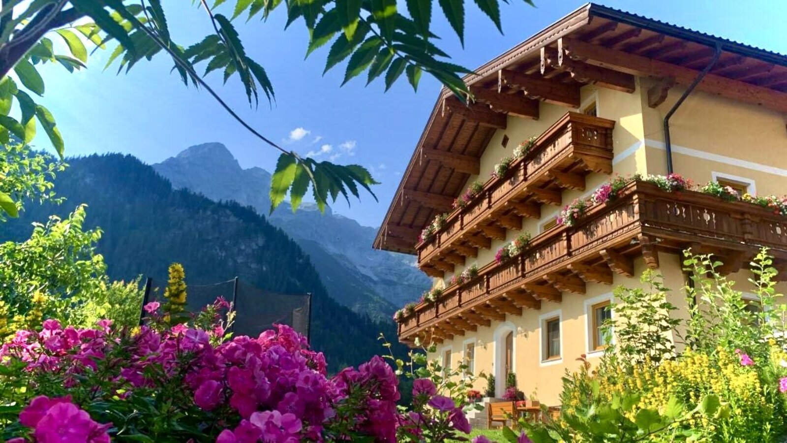 Außenansicht des Bauernhauses mit Sitzgelegenheiten vor und neben dem Haus.
